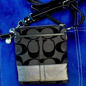 Black signature chambray and smooth leather. Crossbody and inside pocket.